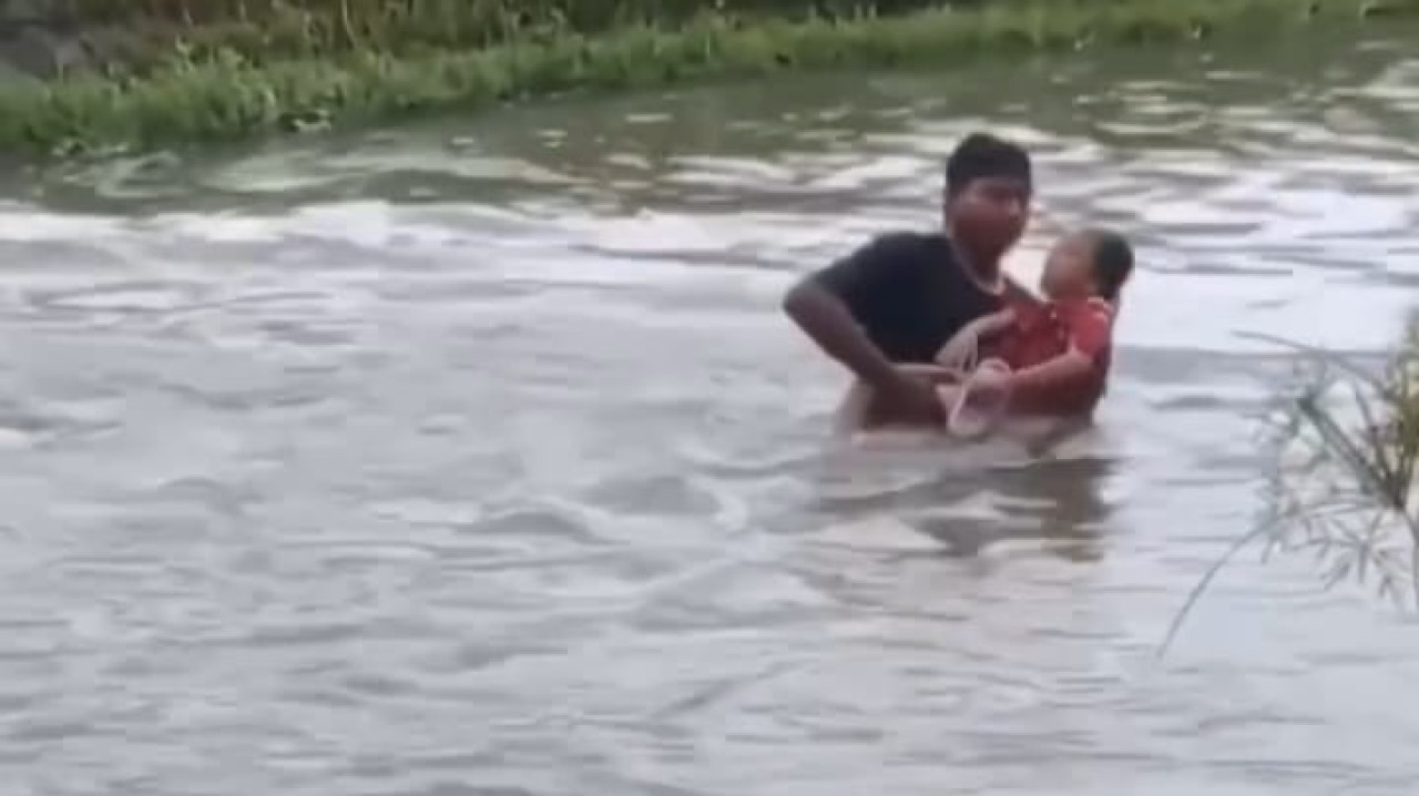 Foto: Capture video aksi penyelamatan bocah hanyut di Tulungagung. (facebook/jatimnow.com)