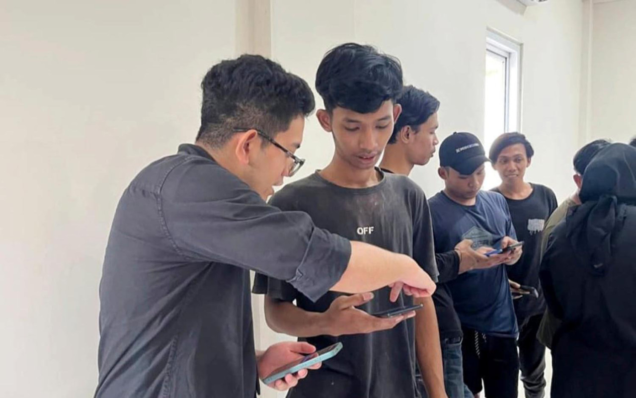 Tim BRI memastikan setiap pekerja bisa mengoperasikan fitur perbankan digital di ponsel mereka sendiri. (Foto/jatimnow.com).