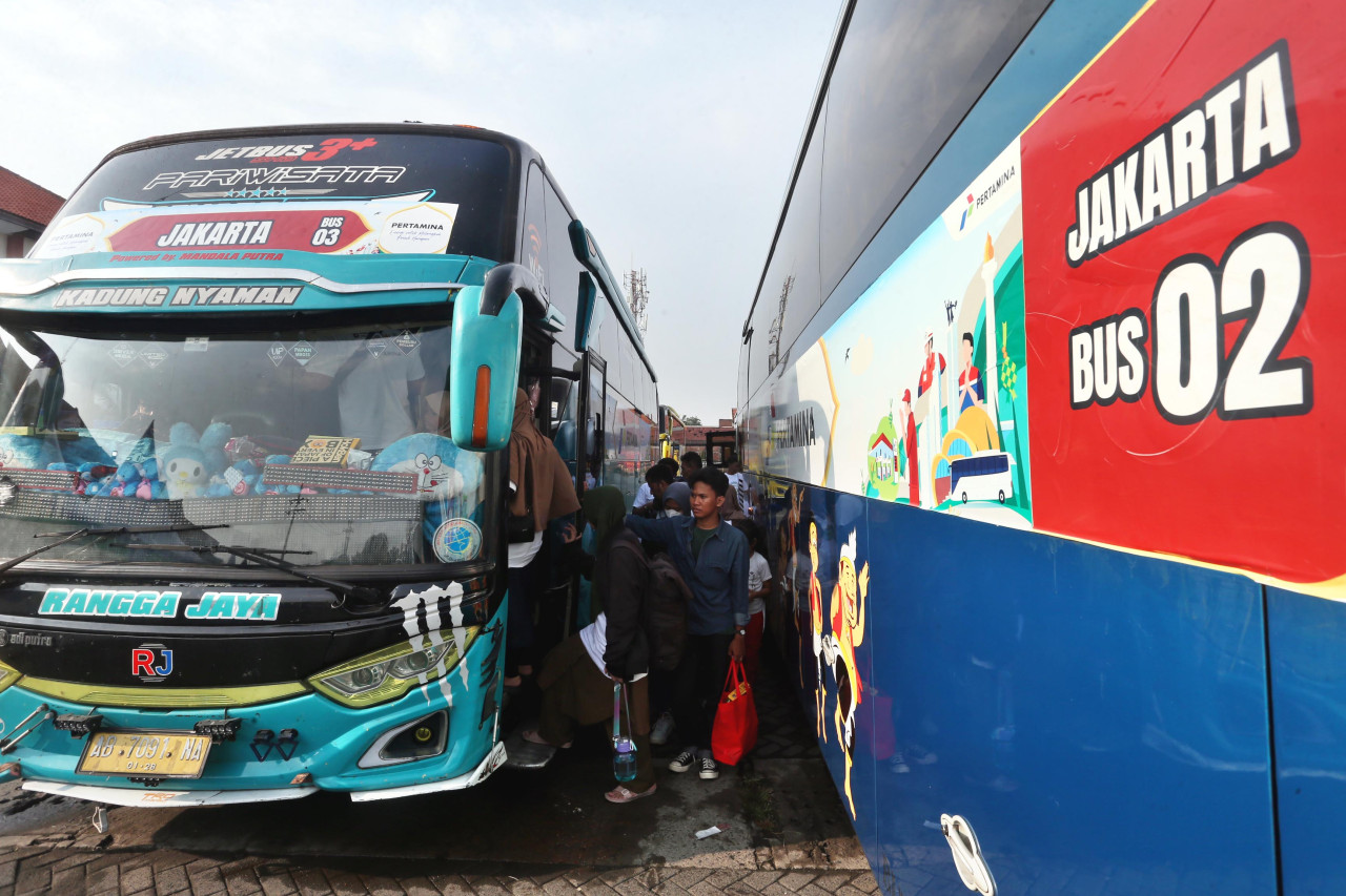 Pemudik bersiap naik bus tujuan Jakarta dalam program arus balik gratis Pertamina di Surabaya, Sabtu (28/3/2026). (Foto: Ali Masduki/jatimnow.com)