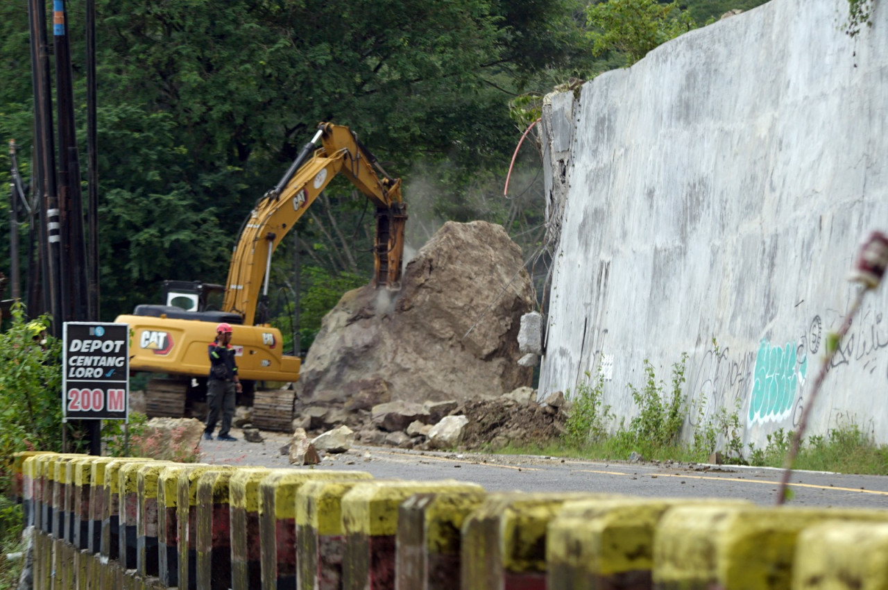 Foto: Proses evakuasi material batu yang menutup akses jalan utama di Trenggalek. (Bramanta/jatimnow.com)