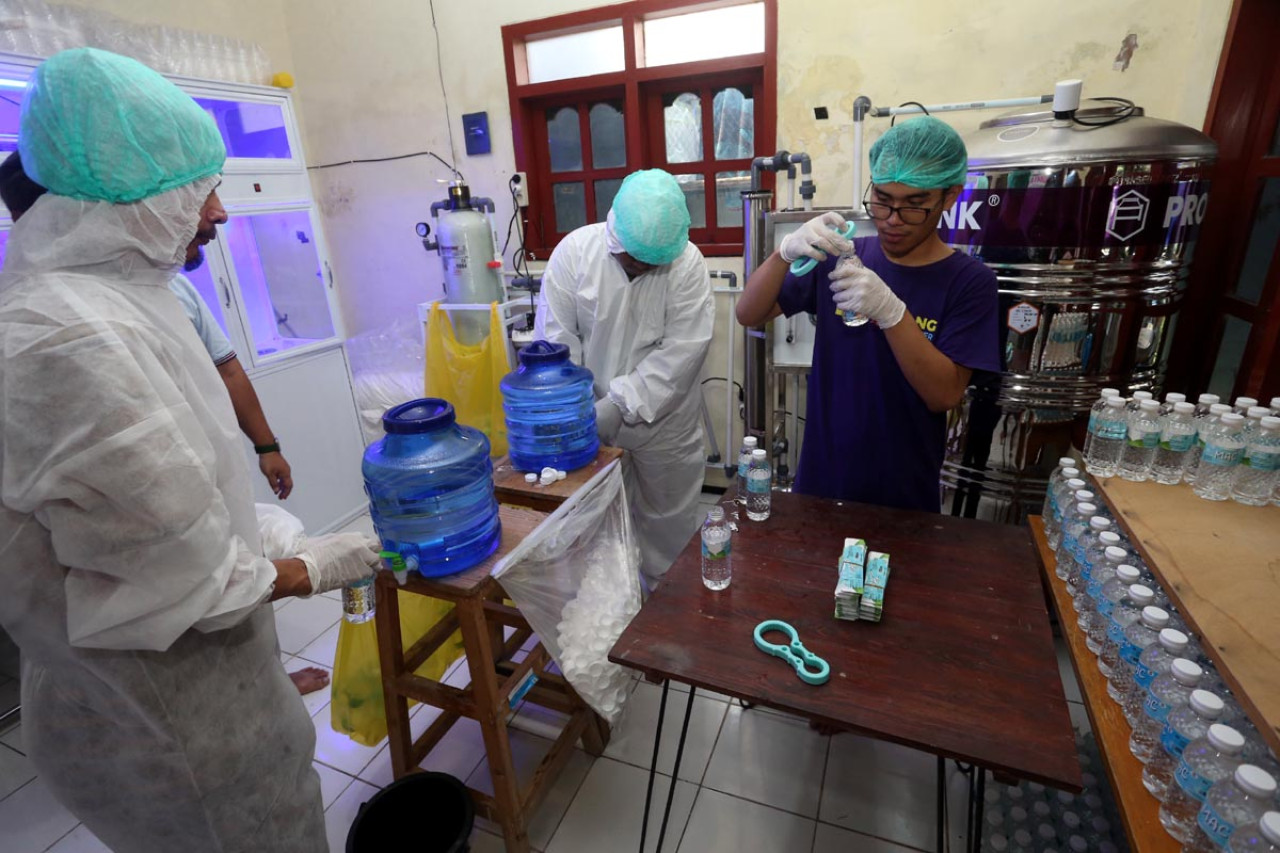 Sejumlah remaja autisme menyelesaikan produksi air minum kemasan bernama MAC Water, di Malang Autism Center (MAC). (Foto: Ali Masduki/jatimnow.com)