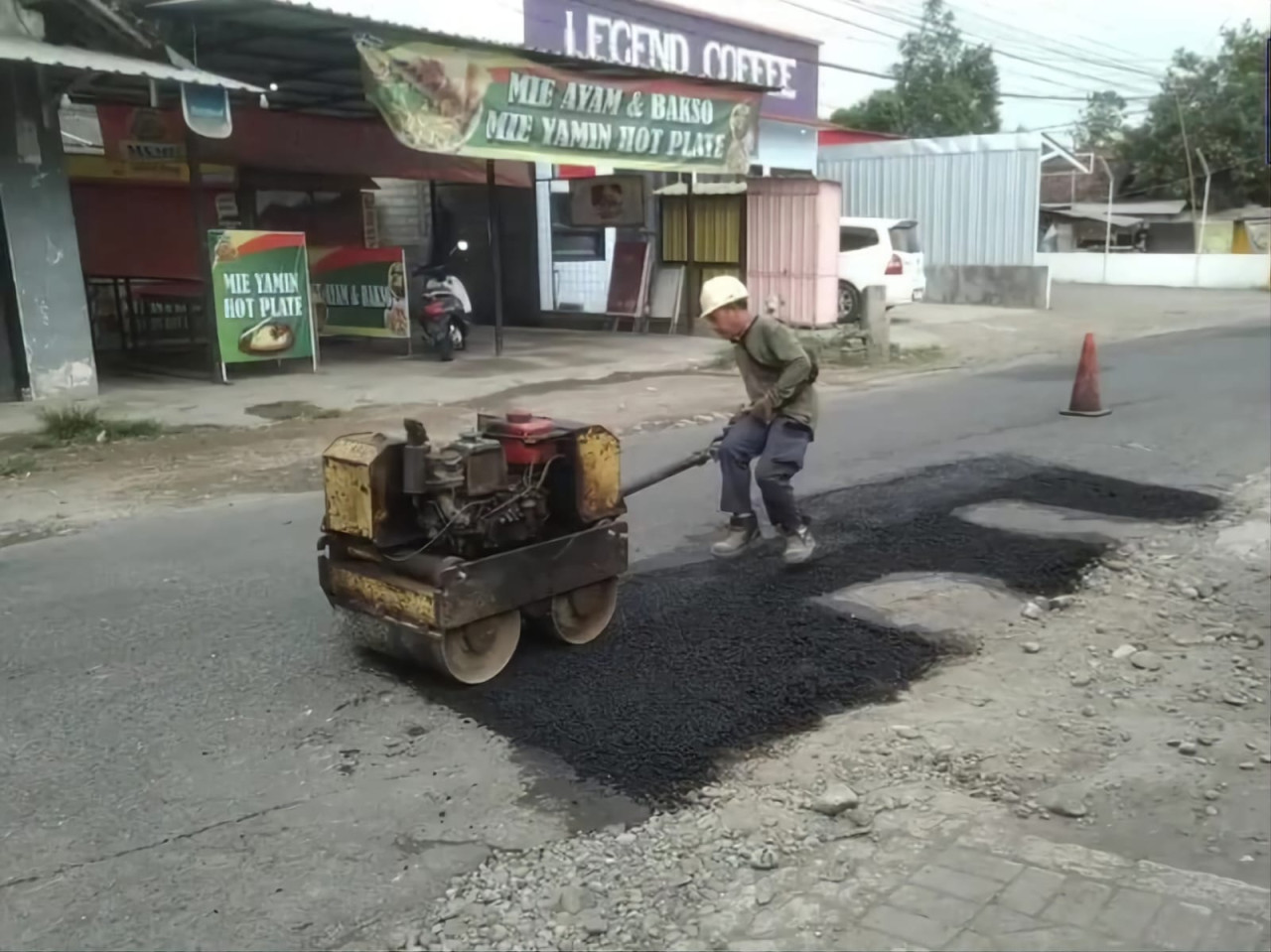 Pekerja sedang memperbaiki ruas jalan di Tulungagung. (Foto: Bramanta/jatimnow.com)
