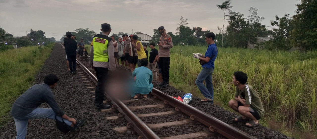 Polisi saat mengevakuasi jenazah korban tanpa identitas. (Foto: Bramanta/jatimnow.com)