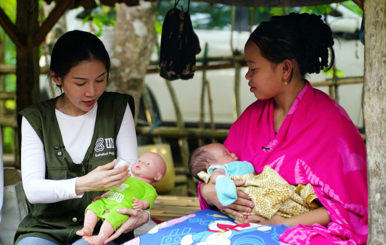 Uung Victoria Finky memberikan edukasi teknik menyusui kepada seorang ibu di Pulau Kangean melalui praktik langsung menggunakan alat peraga. (Foto: Mom Uung for jatimnow.com)