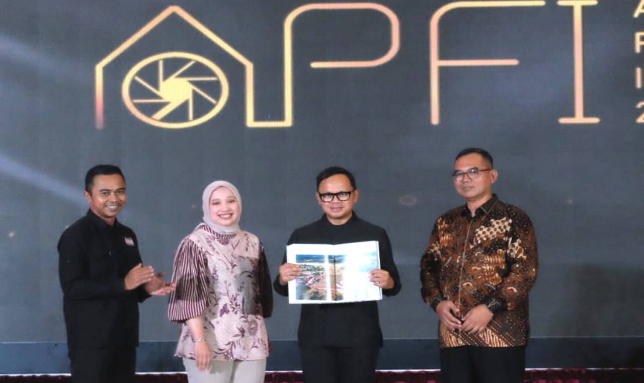 Wamendagri Bima Arya Sugiarto menunjukkan Buku Foto APFI 2026 saat peluncuran di Bogor. (Foto: PFI for jatimnow.com)