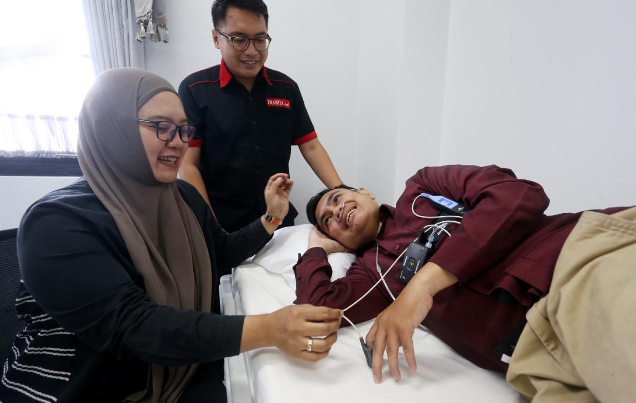 Sleep Technician sekaligus Direktur Resindo Medica, Andini Ekawati, memperagakan penggunaan alat Apnea Link di Pramita Ngagel, Surabaya, Sabtu (16/5/2025). (Foto: Ali Masduki/jatimnow.com)