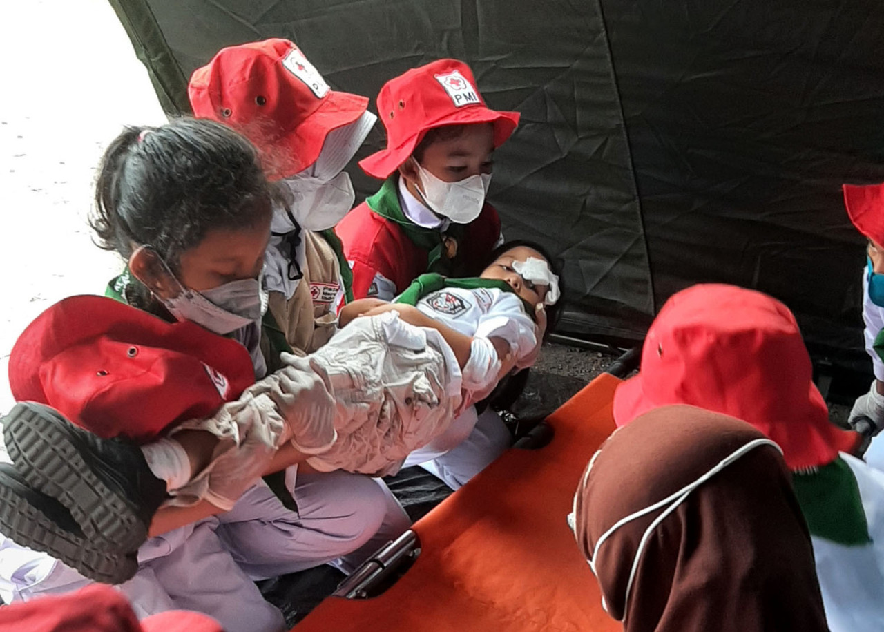 Anggota PMR tingkat SD mempraktikkan teknik evakuasi korban dalam Latihan Gabungan PMR Kota Surabaya 2026 di Unitomo, Surabaya, Sabtu (20/6/2026). (Foto: Humas Unitomo for jatimnow.com)