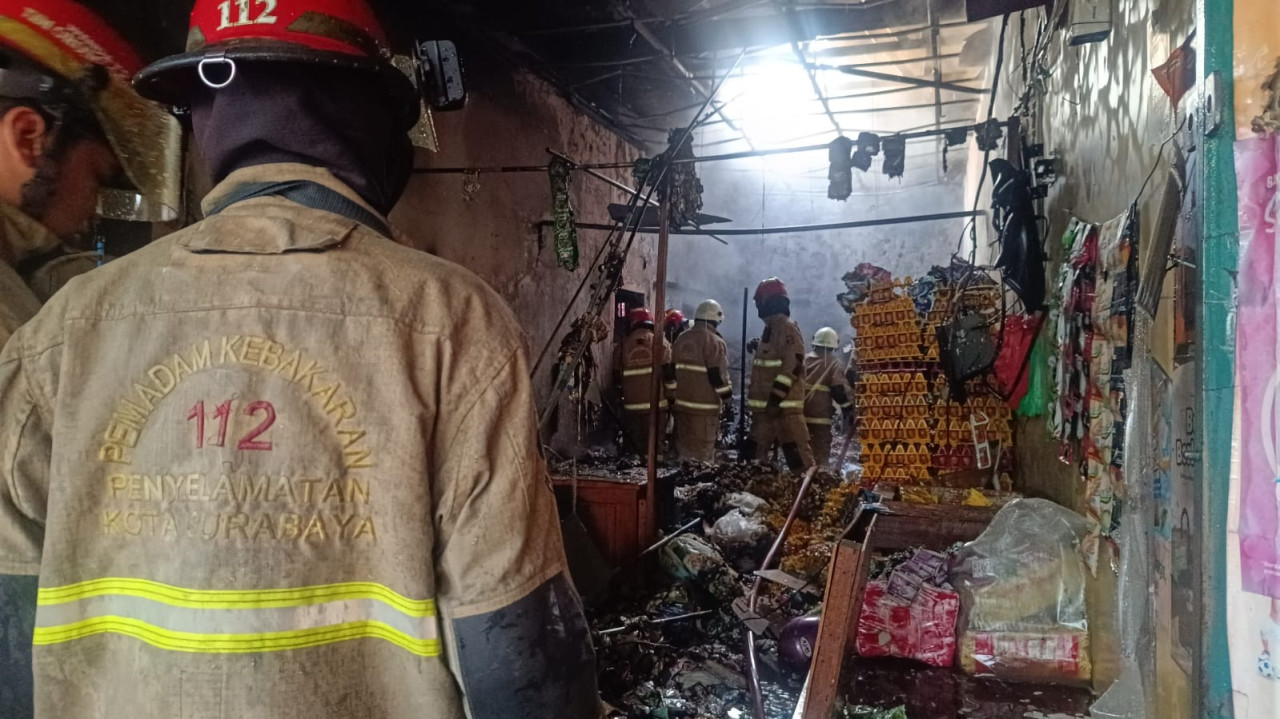 Petugas berada di lokasi kebakaran toko sembako di Surabaya. (Foto: Fatkhur Rizky/jatimnow.com)