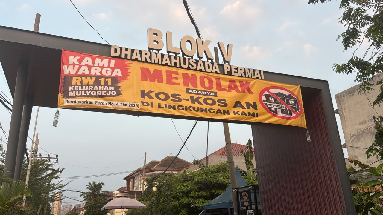 Baliho penolakan dipasang di gapura pintu masuk, perumahan RW 11 (foto: Jozua for jatimnow.com)