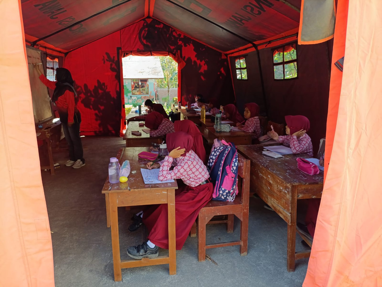 Siswa kelas 2 SDN 3 Wonorejo Tulungagung saat mengikuti pelajaran di dalam tenda. (Foto: Bramanta/jatimnow.com)