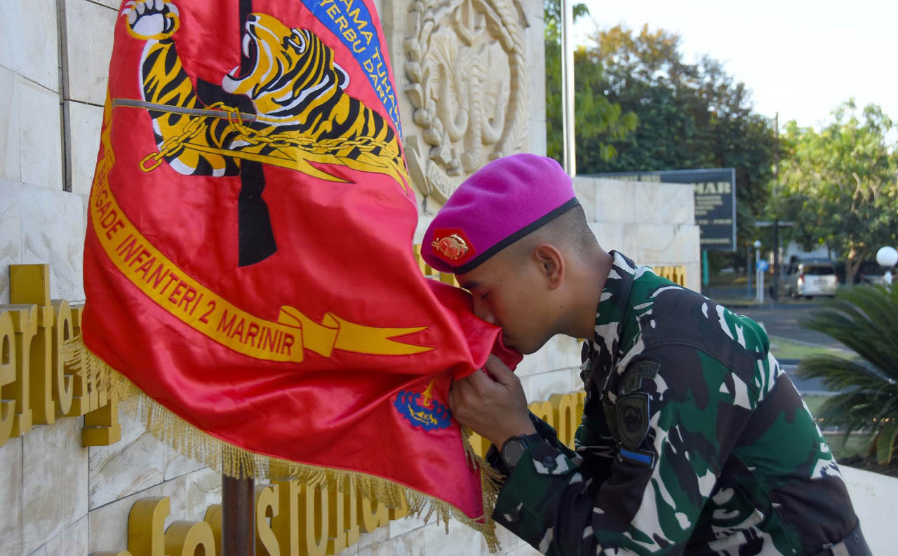 Seorang prajurit muda Korps Marinir mencium Pataka Brigif 2 Marinir usai resmi diterima sebagai anggota satuan dalam upacara penerimaan di Sidoarjo, Rabu (16/7/2026). (Foto: Ainul Yakin for jatimnow.com)