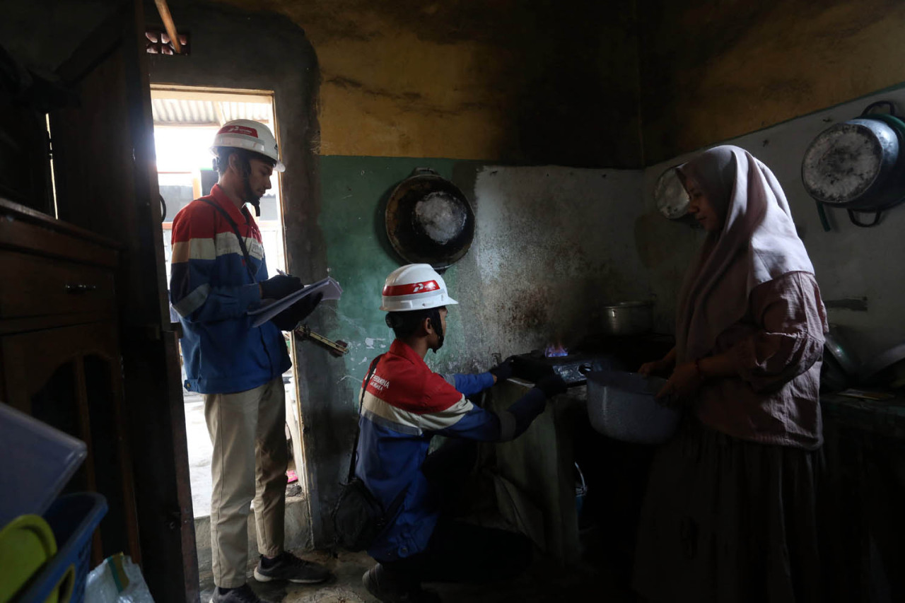 Dua petugas PT Perusahaan Gas Negara (PGN) melakukan pengecekan kompor Ernawati, pelanggan Jargas PGN di Kabupaten Lumajang, Senin (03/8/2026). (Foto: Ali Masduki/jatimnow.com)