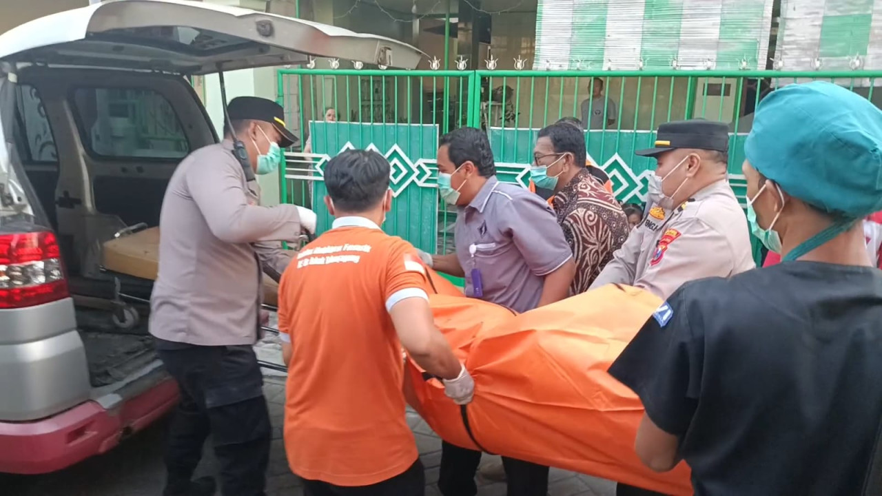 Petugas mengevakuasi jenazah korban dari dalam kamar kos. (Foto: Bramanta/jatimnow.com)