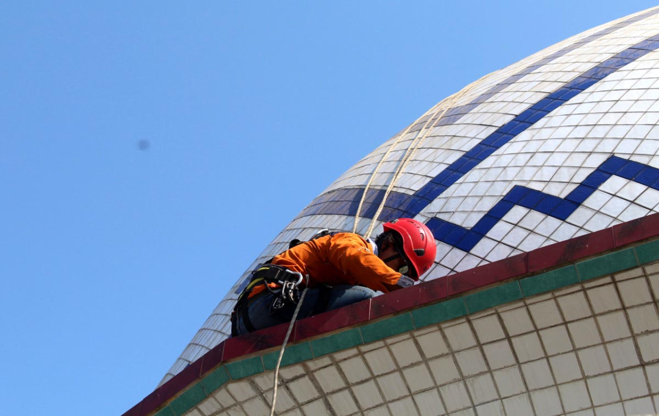 Salah satu personel membersihkan kubah Masjid Baitul Mujtahidin, Desa Wadungasri, Kecamatan Buduran, Sidoarjo. (Foto:  Aston Sidoarjo for jatimnow.com)