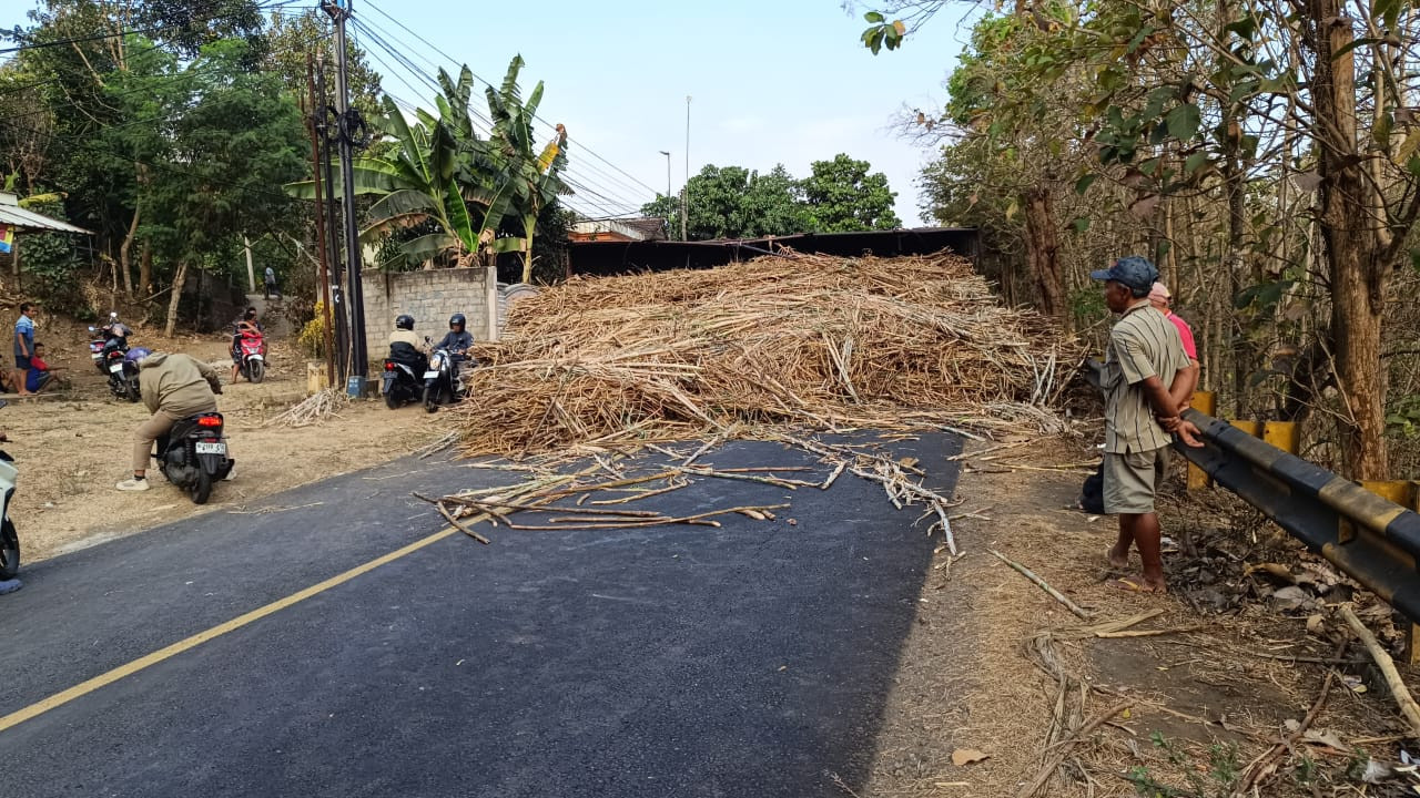 Truk bermuatan tebu terguling dan melintang di Jalan Desa Kalilegi, Kecamatan Selorejo, Kabupaten Blitar. (Foto: Bramanta Pamungkas/jatimnow.com)