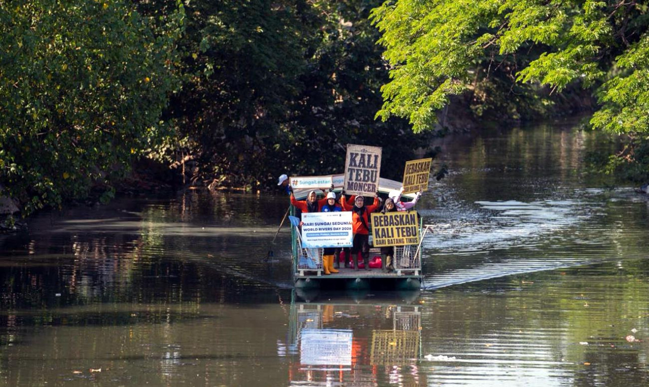 Sejumlah relawan membentangkan poster ketika menyusuri sungai dalam aksi pembersihan massal di Kali Tebu, Surabaya, Jawa Timur, Minggu (27/9/2026). (Foto: Ecoton for jatimnow.com)