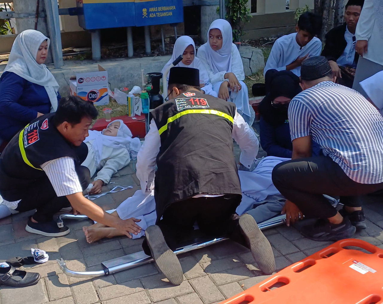 Penanganan peserta pingsan dan kelelahan saat upacara HSN 2026 di Pemkab Lamongan. (Foto : Adyad Ammy Iffansah/jatimnow.com)