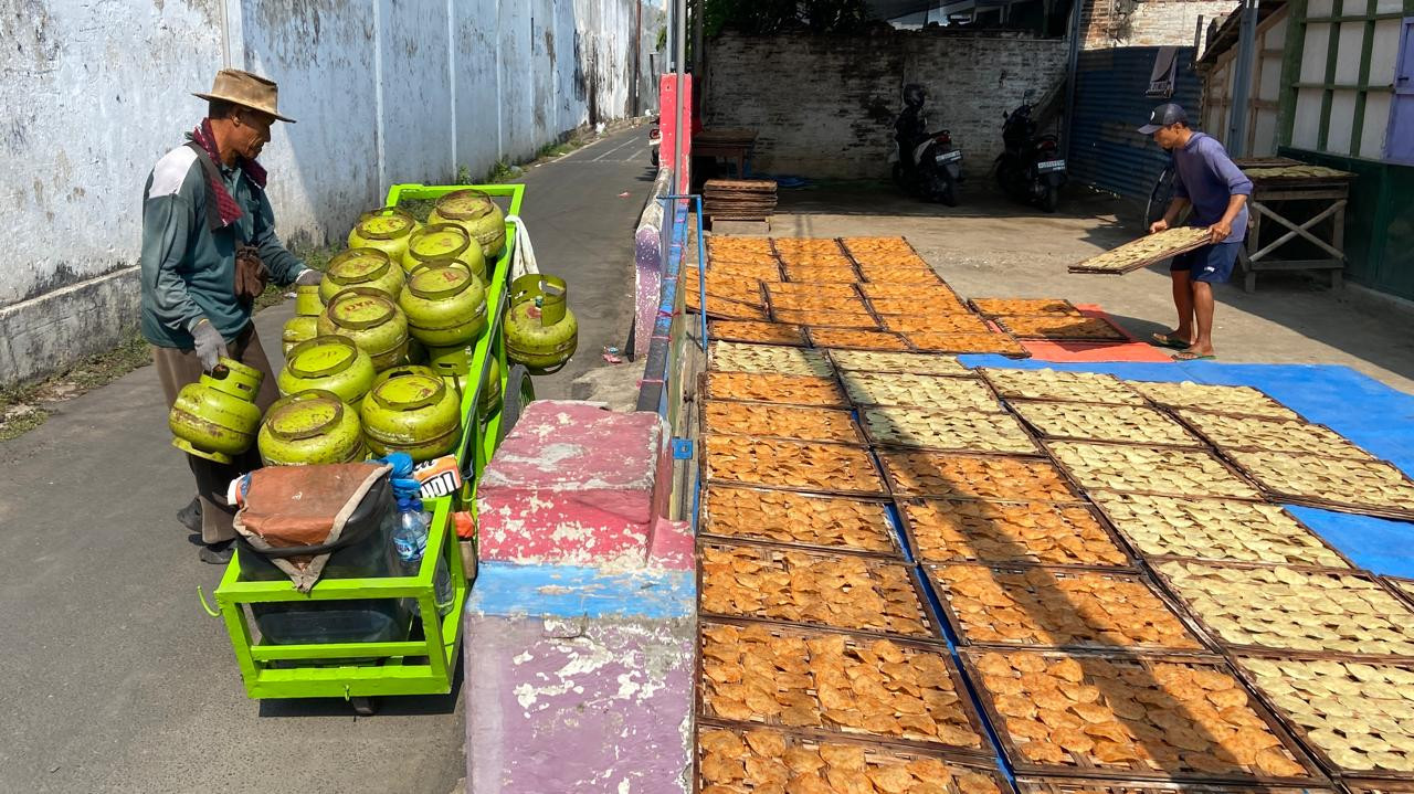 Penjual mengirim kebutuhan LPG 3 kilogram di Kampung Emping Belinjo, Kecamatan Pare, Kabupaten Kediri, Kamis (8/10/2026). Pemandangan tersebut memperlihatkan dua sumber energi yang hadir dalam aktivitas produksi emping. (Foto: Yanuar Dedy/jatimnow.com)