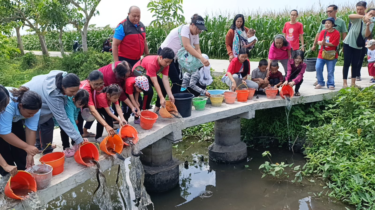 Umat Buddha Tulungagung saat melepaskan ikan. (Foto: Bramanta/jatimnow.com)