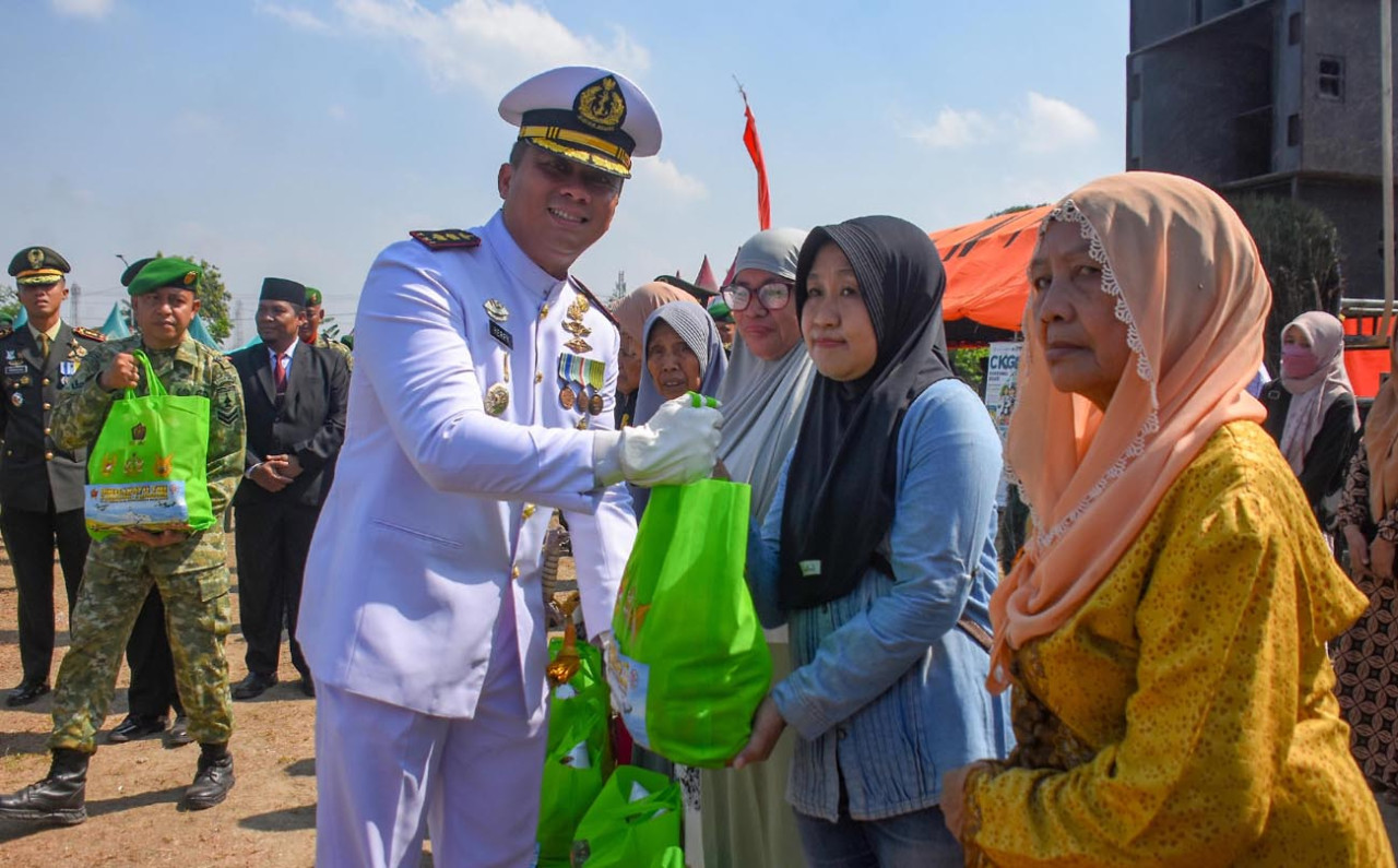 Jajaran TNI menyalurkan paket sembako kepada warga sekitar sebagai wujud nyata menjaga kemanunggalan prajurit dengan masyarakat.(Foto: Ainul Yaki for jatimnow.com)