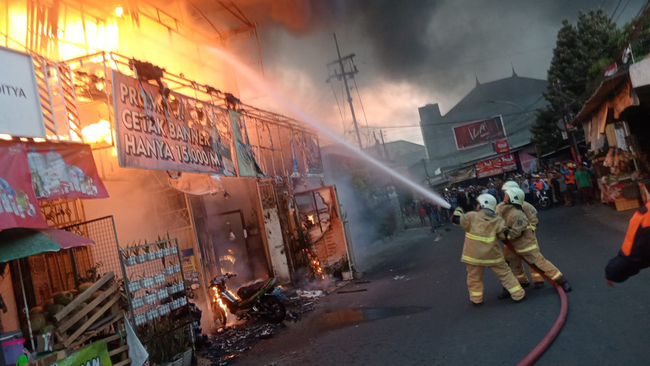 Petugas pemadam kebakaran memadamkan api di percetakan Al-Yaubi Color Print Surabaya. (Foto: DPKP for jatimnow.com)