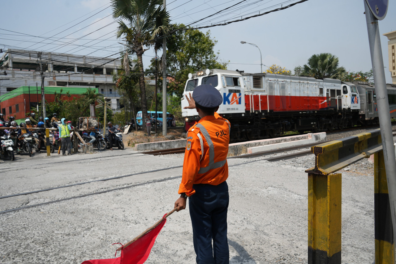 Petugas jaga ekstra KAI Daop 8 Surabaya saat melakukan penjagaan di Jalur Perlintasan Langsung (JPL) di Lamongan. (Foto: Humas Daop 8 Surabaya for jatimnow.com)