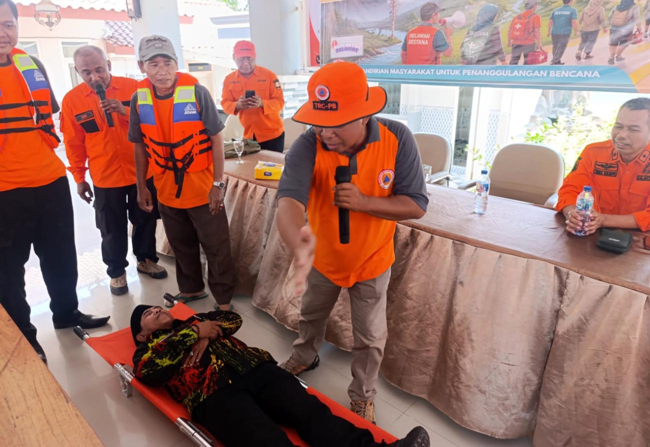 Camat Besuki, Yakub, rela mengambil peran sebagai korban dan ditandu oleh tim penyelamat saat pelatihan evakuasi berlangsung di balai desa setempat. (Foto/jatimnow.com)
