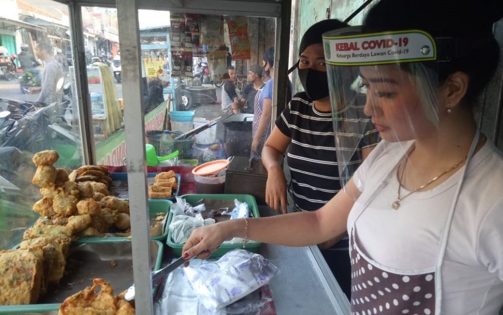 Linda melayani pembeli gorengannya. (Foto-foto: Moch Rois/jatimnow.com)