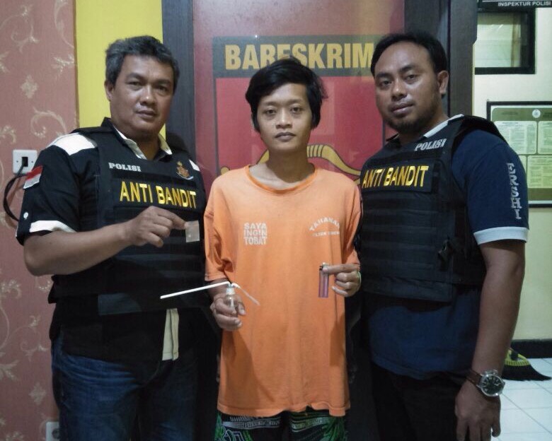 Feri Ardianto  diapit petugas di Mapolsek Gubeng Surabaya.