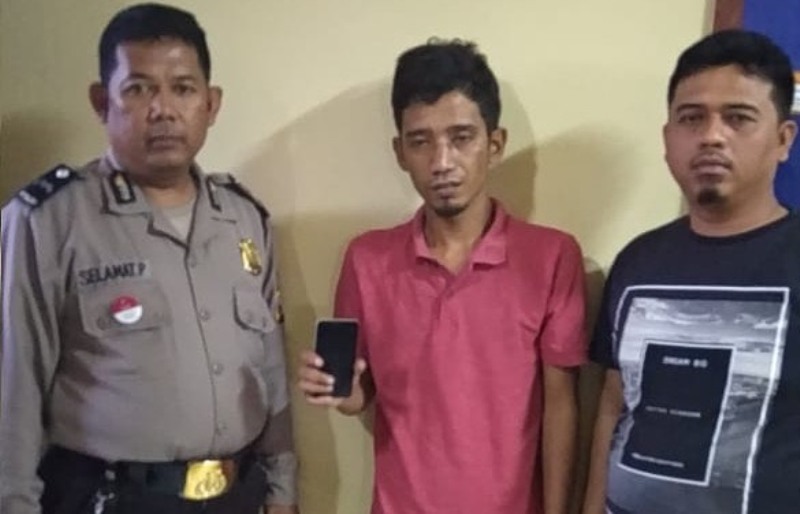 Yoga (tengah) menunjukkan HP korban yang dirampasnya.