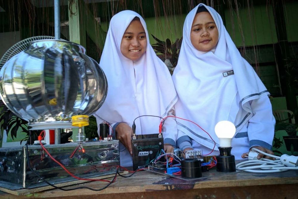 Dua dari tiga pelajar MAN 1 Ponorogo menunjukkan rangkaian alat pembangkit listrik tenaga angin ciptaan mereka