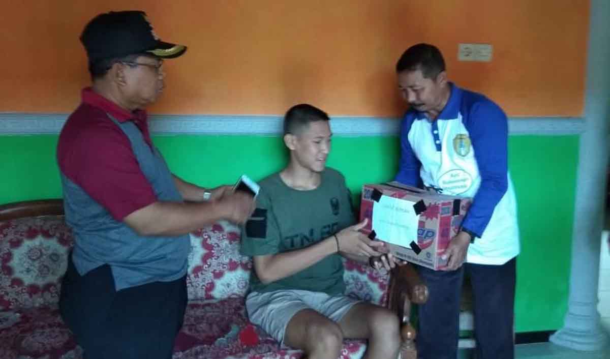 Ananda Micola (duduk) saat menerima bantuan dari salah satu pihak