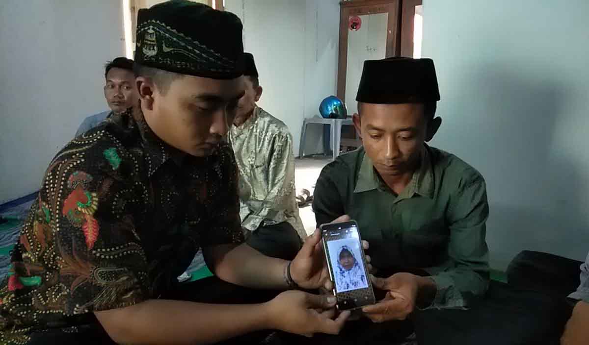 Kedua anak korban menunjukkan  foto semasa hidup ibunya