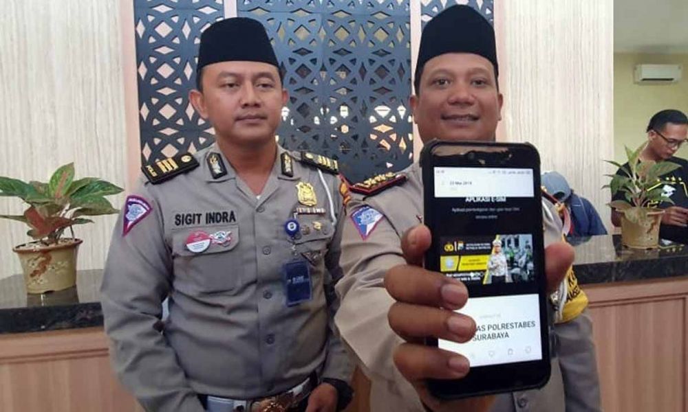 Kasatlantas Polrestabes Surabaya, AKBP Eva Guna Pandia (kanan) menunjukkan aplikasi e-SIM Surabaya