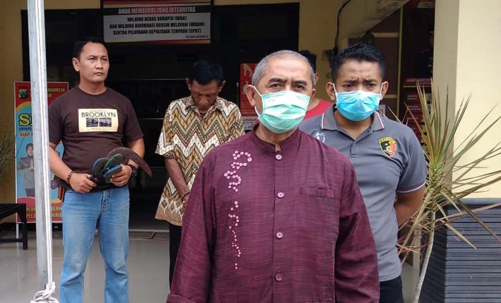 Suratno diamankan di Mapolsek Sukorejo Ponorogo bersama sabit yang dipakainya membacok Langgeng