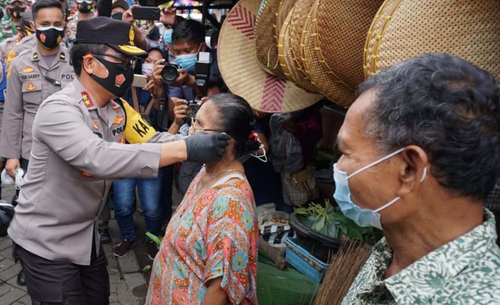 Momen di saat Kapolda Jatim Irjen Pol Nico Afinta memakaikan masker kepada pedagang Pasar Simo, Surabaya