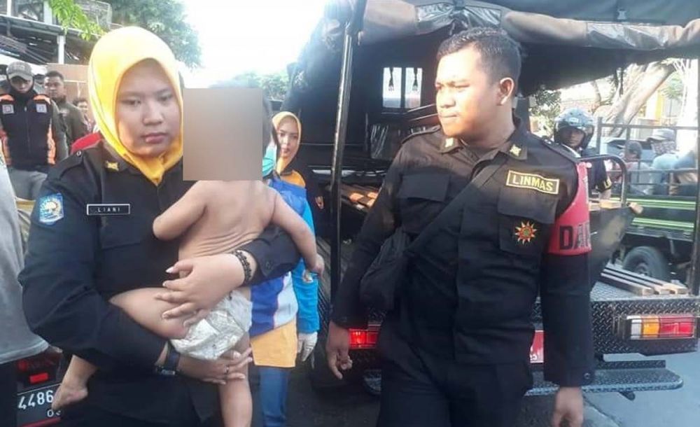 Patugas BPB Linmas Kota Surabaya mengevakuasi Andra, balita yang diikat ayahnya sendiri (foto: Istimewa)