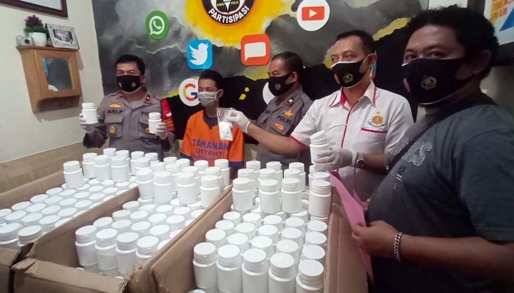 Kapolsek Balongbendo, Kompol Ari Priambodo (kiri) menunjukkan barang bukti pil double l dan tersangka