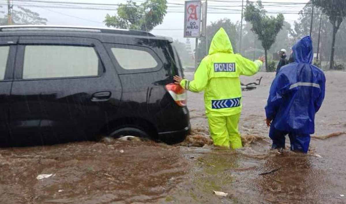 Polisi dan warga mengatur lalu lintas dan membantu kendaraan mogok di Jalan Raya Malang-Surabaya 