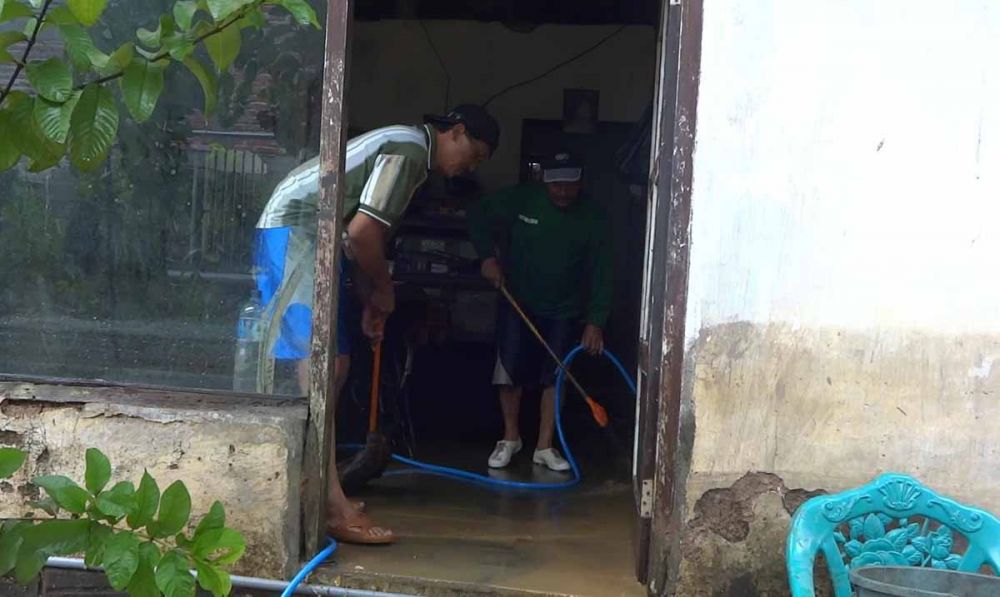 Warga di Trenggalek membersihkan material banjir yang mulai surut 
