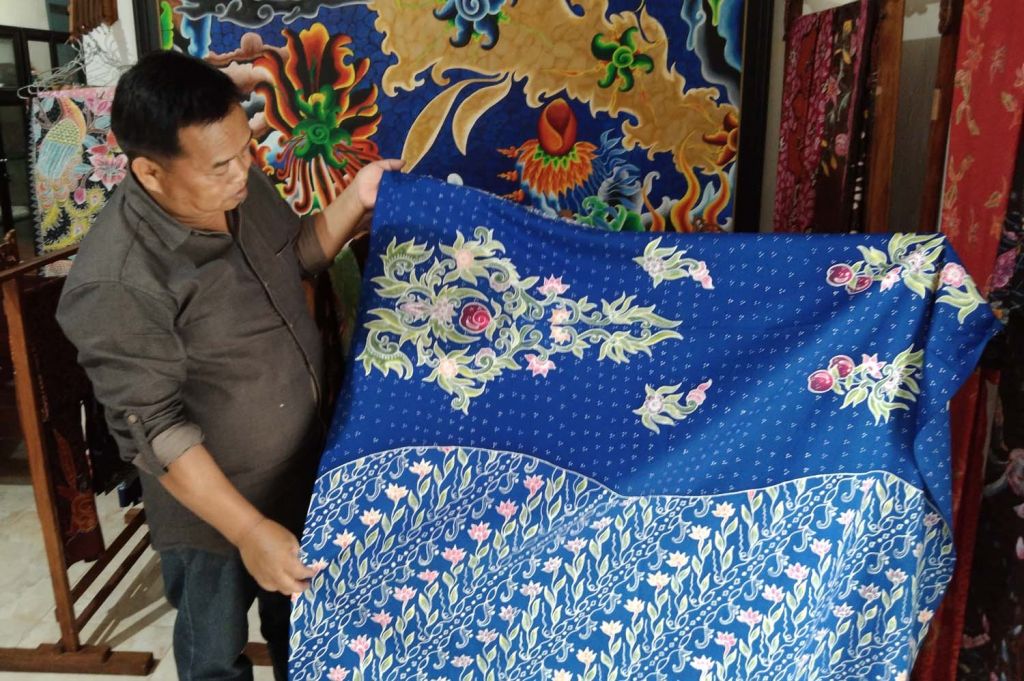 Sumari menunjukkan batik motif apel Kota Batu yang diproduksinya
