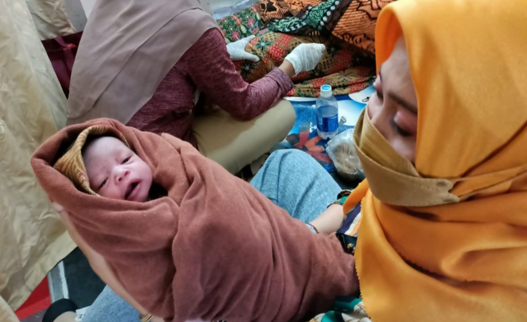 Plt Kepala Dinas Kesehatan Gresik dr Mukhibatul Khusnah bersama bayi yang lahir di atas kapal (Foto: istimewa)