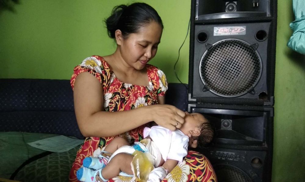 Nanik menggendong Naufal, anaknya yang lahir tanpa lubang anus