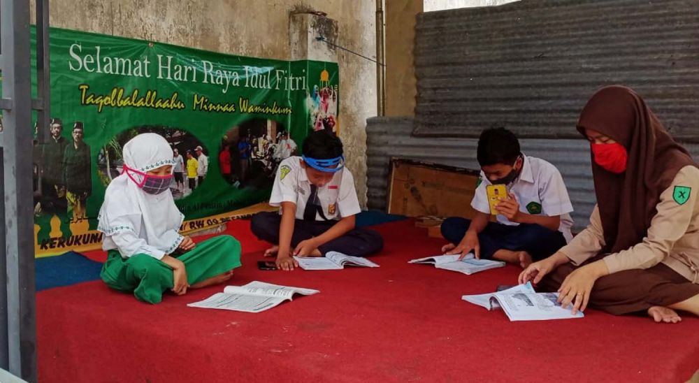 Para pelajar memanfaatkan wifi di pos ronda salah satu dusun di Kota Batu