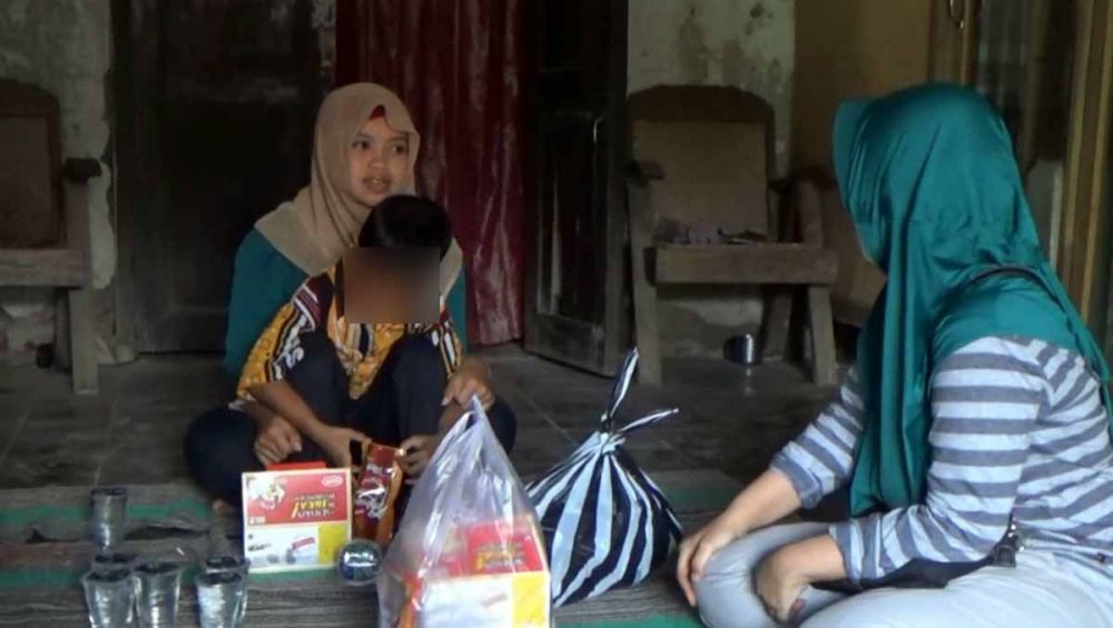 Ilham, bocah dengan kelainan alat kelamin digendong Pramestia Ayu, kakak kandungnya 