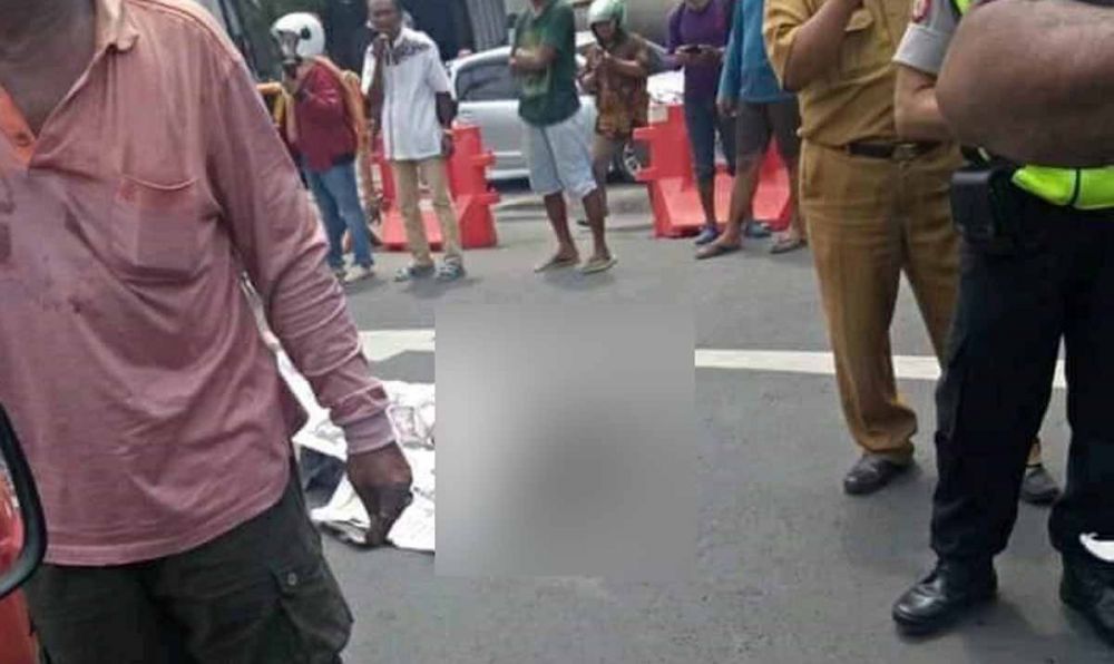 Tubuh seorang bonek yang tewas kecelakaan di Surabaya ditutupi koran sebelum dievakuasi (foto: Istimewa)