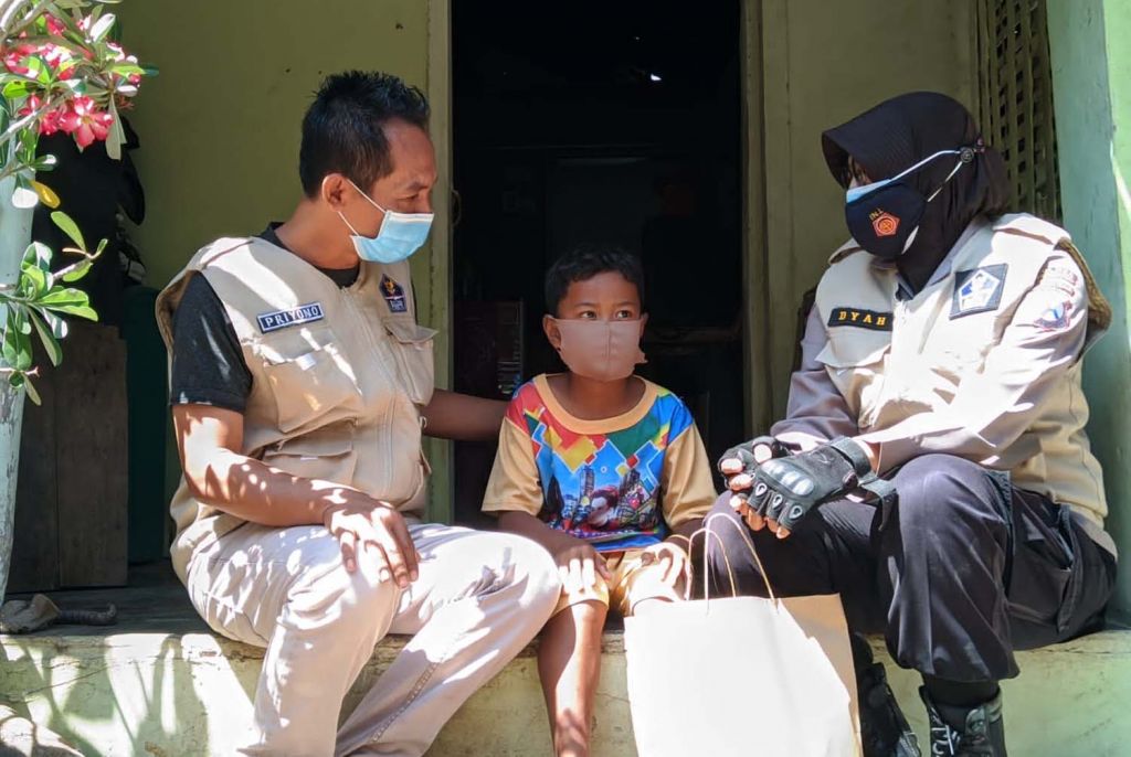 Polisi memberikan bantuan kepada salah satu anak yatim akibat Covid-19 di Ponorogo