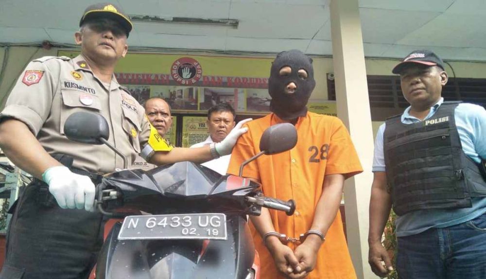 Aziz (pakai kerpus) saat diamankan di Mapolsek Tandes Surabaya bersama motor yang dicurinya