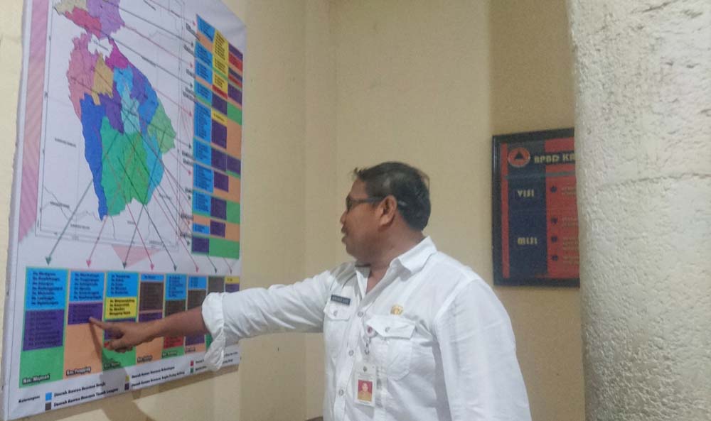 Kepala Pelaksana Badan Penanggulangan Bencana Daerah Kabupaten Mojokerto, Muhammad Zaini saat melihat peta bencana Kabupaten Mojokerto./ Foto: Khilmi Sabikhisma Jane.