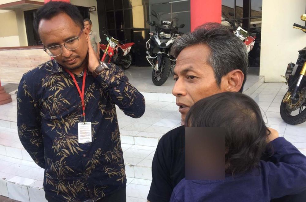 Daru Asmara Jaya (kanan) menggendong anak ketiganya saat berada di Mapolrestabes Surabaya